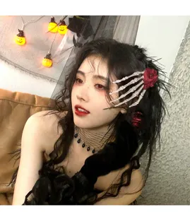 Gothische Skeletthand Haarklammer mit roter Rose an einem Model für Halloween Deko