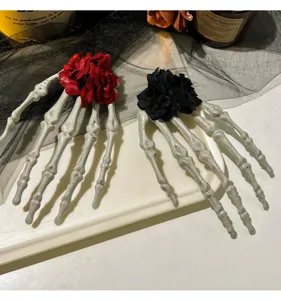 Detailansicht von gotischen Skeletthand-Haarspangen mit roten und schwarzen Rosen