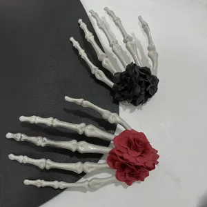 Detailansicht gotischer Skeletthand-Haarklammern mit schwarzen und roten Rosen.