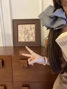Λεπτομέρεια ενός μεγάλου καρό scrunchie σε λευκό και μαύρο σε καστανά μαλλιά