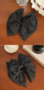 Vue détaillée de la pince à cheveux à nœud triple épaisseur à pois noirs et blancs
