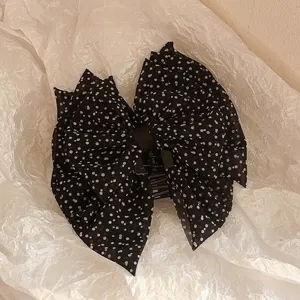 Pince à cheveux élégante avec grand nœud à pois noirs et blancs pour femme.