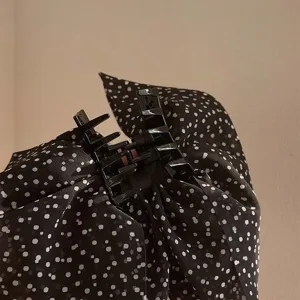 Pince à cheveux nœud à pois noirs avec un design élégant à plusieurs couches pour femmes.