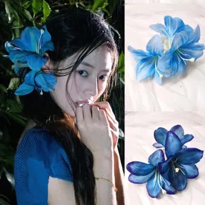 Vista detallada de la pinza para el pelo con flor de lirio azul en modelo y fondo de tela