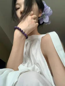 Primer plano de una pinza para el pelo con forma de flor morada usada por una modelo.