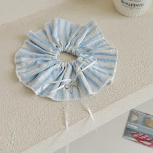 Nahaufnahme eines blau-weiß gestreiften Spitzen-Scrunchies mit einer weißen Schleife.