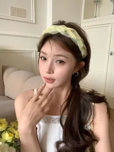 Asian model wearing a stylish yellow braided wide headband for elegant high-top hair look