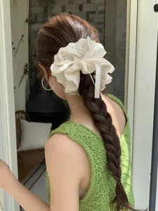 Detailed view of large four-layer lace scrunchie with drawstring on braided hair