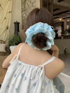 Detailed shot of a four-layer light blue lace drawstring scrunchie on a hair bun