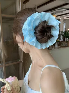 Detailed view of a light blue four-layer lace drawstring scrunchie on a model bun