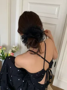 Detailansicht eines großen schwarzen Organza-Haargummis bei einer eleganten Dutt-Frisur