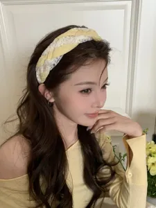 Detailed view of stylish yellow and white lace braided wide-sided headband on model