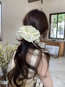 Detail view of a stylish four-layer cream lace scrunchie with adjustable drawstring ribbon