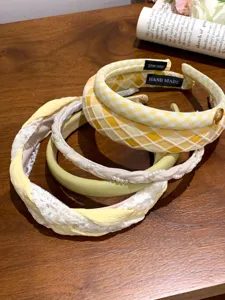 Detailed view of yellow and cream wide-edge fashion headbands for women