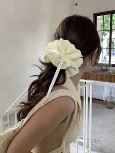 Detailed view of cream lace scrunchie with adjustable drawstring ribbon on hair.
