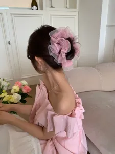 Detail eines rosa gerafften Organza-Haargummis im Ballett-Stil auf einem Dutt
