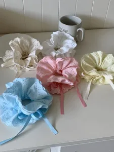 Close-up of assorted four-layer lace ruffle scrunchies with adjustable ribbon ties