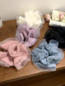 Detailaufnahme von bunten, plissierten Organza-Haargummis auf einer Holzoberfläche