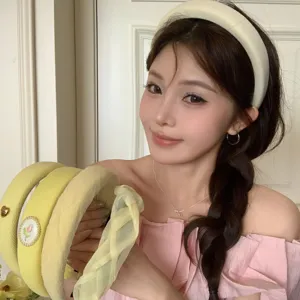 Stylish yellow wide-brim headband set for a high-skull-top look on an Asian model.