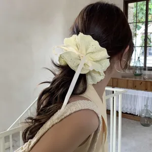 Four-layer lace drawstring scrunchie in cream yellow worn by a model in a natural setting
