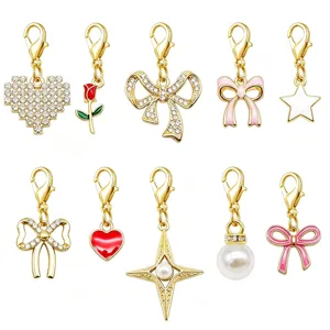 Assorted gold lobster clasp charms with heart, bow, and pearl designs for DIY jewelry