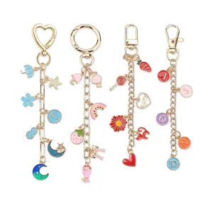 Détail des pendentifs alphabet colorés et des breloques sur des porte-clés DIY dorés