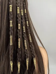 Dettaglio di anelli e polsini per capelli dorati su lunghe trecce di capelli castani