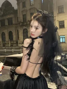Detailed look of gothic black Halloween veil with butterfly and pearl accents on model