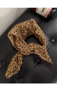 Detailopname van een hoofddoek met luipaardprint op een zwarte lederen achtergrond