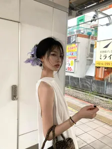 Pinza para el pelo con flor morada grande usada por una modelo en un entorno chic.
