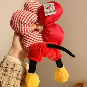 Detailansicht eines niedlichen Micky Maus Plüsch-Haargummis mit roten Shorts und Schuhen.