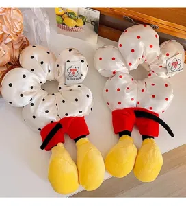 Detailaufnahme süßer Mickey Mouse Plüsch-Haargummis mit gepunktetem Satinstoff.
