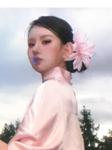 Primer plano de una pinza para el pelo con lirio rosa etéreo lucida por una modelo