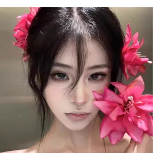 Primer plano de una pinza para el pelo con flor de lirio rosa en una modelo estética