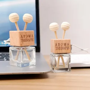 Square glass car diffuser bottle detail with wooden cap and cute lollipop diffuser sticks.