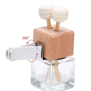 Car vent aromatherapy bottle detail view, wooden diffuser sticks and adjustable white clip.