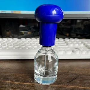 Perfume bottle crimping tool detail, manual press applicator for spray pump dispensing.