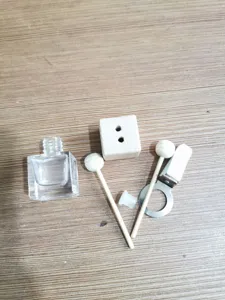 Detail shot of car air vent diffuser spare parts including square glass bottle and clip.