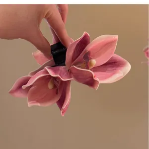 Detailed view of elegant pink orchid floral hair claw clip featuring realistic petals