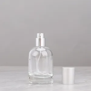 Detail shot of a transparent glass perfume spray bottle with silver pump and cap, portable design.