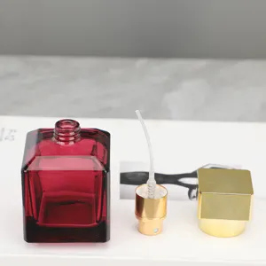 Detailansicht der quadratischen Glas-Parfümflasche mit Goldspray und passender Kappe.