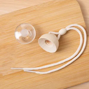 Detalle de tapa de botella de perfume para auto de madera con cuerda y tapón de plástico.