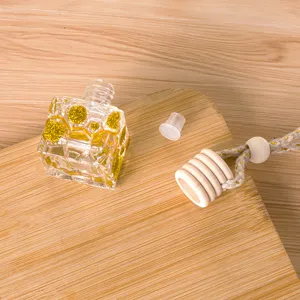 10ml glazen auto parfumflesje met gouden glitter, houten dop en handig ophangtouw.