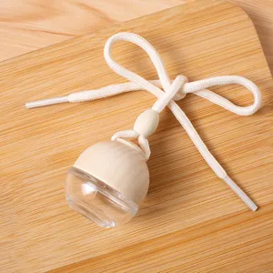 Vista detallada frasco perfume coche de vidrio con tapa de madera y cuerda blanca.