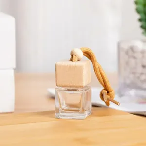 Dettaglio in primo piano di flacone di profumo quadrato in vetro con tappo in legno.