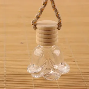 Flacon de parfum de voiture en verre transparent avec bouchon en bois et corde de suspension.