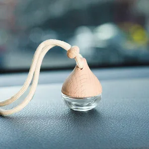 Gros plan détaillé du pendentif flacon de parfum pour voiture en verre avec bouchon en bois.