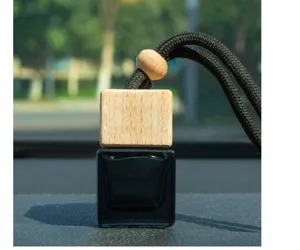 Detailed view of square black car perfume bottle with wooden cap and black hanging rope.