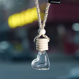 Detailopname van hartvormige glazen auto parfum fles, etherische olie diffuser hanger.
