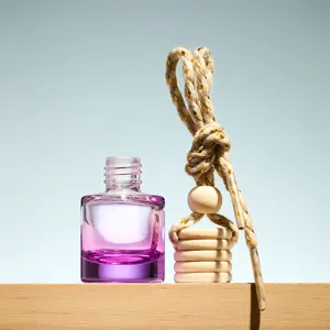 Detailed shot of empty glass car perfume pendant bottle with wooden cap and hanging rope.